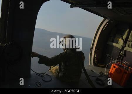 Oregon Army National Guard UH-60 Blackhawk capo equipaggio, staff Sgt. Elana Cleveland da G/1-189 Aviation (MEDEVAC) da Salem, Oregon siede in attesa di raccogliere più acqua per condurre gocce aeree secchio su incendi boschivi in Eastern, Oregon, 22 agosto 2020. Gli elicotteri vengono attivati per un periodo di due settimane, assistendo il Dipartimento delle foreste dell'Oregon e le agenzie locali con incendi boschivi che si stanno attualmente svolgendo nell'Oregon orientale. (Oregon National Guard foto di Tech. SGT. Aaron Perkins, Dipartimento militare dell'Oregon) Foto Stock