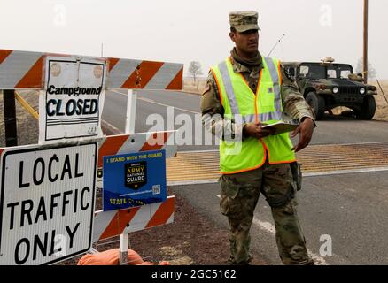 Oregon Army National Guard SPC. Russell Baghdadi, quartier generale e quartier generale Troop, 1 ° squadrone, 82 ° reggimento Cavalry, mans un punto di controllo del traffico (TCP) per aiutare a mantenere il quartiere e la comunità al sicuro, Warms Springs, Ore., 17 settembre 2020. Il fuoco di Lionshead, situato a 14 miglia ad ovest di Warm Springs, potrebbe potenzialmente condurre ad un'evacuazione, lasciando le case vulnerabili. Bagdadi, di stanza presso uno dei quattro TCPS lungo l'autostrada US 26, aiuta a rassicurare i cittadini locali e controlla chiunque entri ed esca dai quartieri, costruendo rapporti forti e positivi con i residenti che vede giorno in un Foto Stock