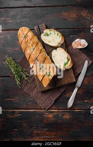 Pane tostato con aglio ed erbe, su vecchio sfondo di legno scuro tavolo, vista dall'alto piatto, con spazio copia per il testo Foto Stock