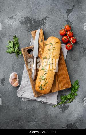 Pane affettato alla griglia con aglio ed erbe, su sfondo grigio del tavolo in pietra, vista dall'alto piatto, con spazio per la copia del testo Foto Stock