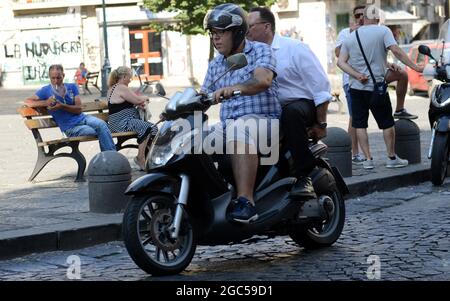 Gli italiani cavalcano i loro scooter in Via Sanità a Napoli. Foto Stock