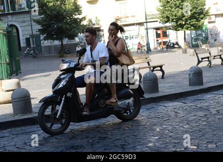 Gli italiani cavalcano i loro scooter in Via Sanità a Napoli. Foto Stock