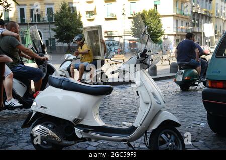 Gli italiani cavalcano i loro scooter in Via Sanità a Napoli. Foto Stock