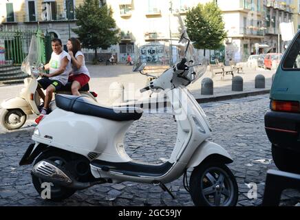 Gli italiani cavalcano i loro scooter in Via Sanità a Napoli. Foto Stock