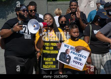 Wasington DC, Stati Uniti. 06 agosto 2021. Un attivista usa un corno per i manifestanti al Martin Luther King Jr Memorial a Washington, D.C, il 6 agosto 2021. Un gruppo di manifestanti bloccherebbe più tardi la strada fuori dal terminal delle American Airlines all'aeroporto nazionale di Reagan come atto di disobbedienza civile per chiedere la statehood del D.C., le riparazioni, la fine del filibuster, e la protezione dei diritti degli elettori e essere arrestato dalla polizia. (Foto di Matthew Rodier/Sipa USA) Credit: Sipa USA/Alamy Live News Foto Stock