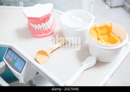 Stucco dentale e modello di mascella umana sul tavolo presso la clinica dentale Foto Stock