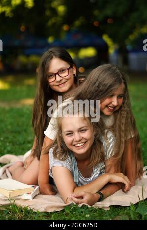 Tre Sorelle sorridenti che si divertono all'aperto. Sorelle insieme per sempre. Buon concetto di famiglia. Primavera, estate. Foto Stock