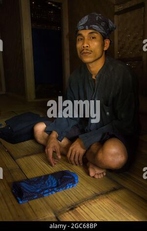 Un uomo Baduy si siede a casa sua. Baduy è una tribù tradizionale di Banten, Indonesia. Mantengono il loro stile di vita tradizionale fino ad ora. Foto Stock