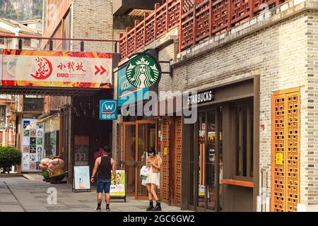 Yangshuo, Cina. 25 luglio 2021. La gente si trova all'ingresso di una caffetteria Starbucks a Yangshuo. (Credit Image: © Thibaud Mougin/SOPA Images via ZUMA Press Wire) Foto Stock