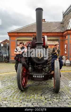 Kidderminster, Worcs, Regno Unito. 7 agosto 2021. I fratelli Edward e Arthur Marriott, 10 e 9 anni, siedono sul loro trattore Fowler D2 tenuto alla Vintage Transport Extravaganza alla stazione ferroviaria di Severn Valley, Kidderminster, Worcs. Credit: Peter Lopeman/Alamy Live News Foto Stock