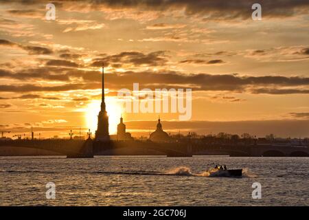 Tramonto sul fiume Neva. Il sole tramonta sotto l'orizzonte. Il cielo e l'acqua sono di colore rosso. Foto Stock