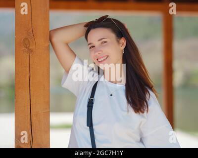 Giovane donna bruna sorridente all'aperto ritratto. Sole primavera o estate giorno in natura Foto Stock