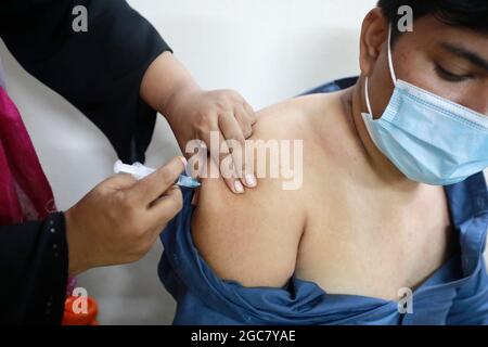 Dhaka, Bangladesh - 07 agosto 2021: La folla di persone viene al Mugda Nagar Maternity Hospital nella capitale per la vaccinazione il primo giorno di corona Foto Stock