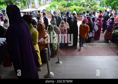 Le persone si accodano per ricevere un colpo del vaccino Mordana COVID19 durante una campagna di vaccinazione di massa presso il centro di vaccinazione degli shamoli a Dhaka, Bangladesh, il 7 agosto 2021. Secondo la direzione Generale dei servizi sanitari del Bangladesh (DGHS), il programma nazionale di vaccinazione di massa inizia con la sua campagna di vaccinazione volta ad iniettare 3.5 milioni di persone in sei giorni. Il Bangladesh ha registrato quasi 1.31 milioni di infezioni da coronavirus e 21,638 decessi dall'inizio della pandemia. Foto Stock