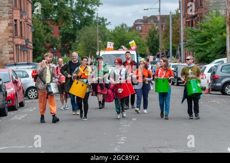 Glasgow, Scozia, Regno Unito. 7 agosto 2021. Musicisti che si esibiscono nella Govanhill Carnival Parade. La parata di quest'anno comprende gruppi di comunità, un piper, batteristi, ballerini, giocolieri, I pattinatori a rotelle e una band di ottone partono da Govanhill Park e viaggiano per le strade di Govanhill fino alla Queen's Park Arena. Credito: SKULLY/Alamy Live News Foto Stock