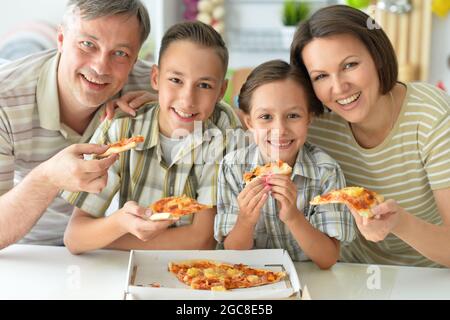 La famiglia felice di mangiare la pizza insieme in autunno park Foto Stock