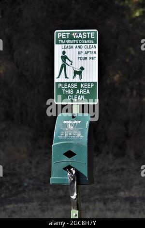 Stazione pubblica di rifiuti per animali domestici per ottenere sacchetti di plastica e poi mettere il doo cane in un cestino dopo che il critter fa la sua cosa sui sentieri della parte Foto Stock