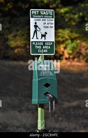 Stazione pubblica di rifiuti per animali domestici per ottenere sacchetti di plastica e poi mettere il doo cane in un cestino dopo che il critter fa la sua cosa sui sentieri della parte Foto Stock