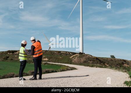Ingegneri persone che usano tablet a energia alternativa verde vento stazione agricola indossare maschere di sicurezza - innovazione e concetto di energia verde Foto Stock