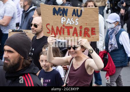 Il manifestante ha un segno di no al pass sanitario durante una giornata nazionale di protesta contro la vaccinazione obbligatoria del Covid-19 per alcuni lavoratori e l'uso obbligatorio del pass sanitario richiesto dal governo francese a Parigi il 7 agosto 2021. Sabato i manifestanti sono scesi per le strade di tutta la Francia per il quarto fine settimana di fila per radunarsi contro un nuovo pass sanitario necessario per entrare in un bar o viaggiare su un treno interurbano, due giorni prima che le nuove regole entrino in vigore. Un pass sanitario valido è generato da due tamponi provenienti da un vaccino riconosciuto, un test del coronavirus negativo o un recente recupero Foto Stock