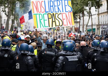 Il manifestante ( Voltuan ) ha dato un segno alla nostra caduta di libertà circondata dalle forze di gendarmeria e dalle forze di polizia durante una giornata nazionale di protesta contro la vaccinazione obbligatoria del Covid-19 per alcuni lavoratori e l'uso obbligatorio del certificato sanitario richiesto dal governo francese a Parigi il 7 agosto; 2021. Sabato i manifestanti sono scesi per le strade di tutta la Francia per il quarto fine settimana di fila per radunarsi contro un nuovo pass sanitario necessario per entrare in un bar o viaggiare su un treno interurbano, due giorni prima che le nuove regole entrino in vigore. Un pass sanitario valido è generato da due tamponi provenienti da un vaccino riconosciuto Foto Stock