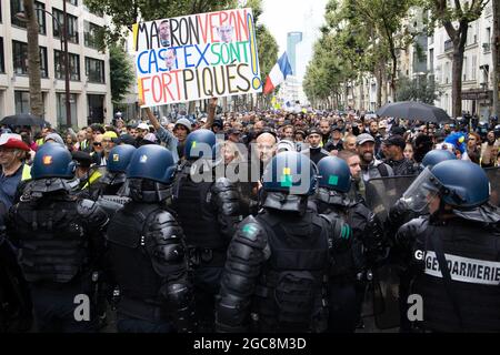 Il manifestante ( Voltuan ) ha dato un segno alla nostra caduta di libertà circondata dalle forze di gendarmeria e dalle forze di polizia durante una giornata nazionale di protesta contro la vaccinazione obbligatoria del Covid-19 per alcuni lavoratori e l'uso obbligatorio del certificato sanitario richiesto dal governo francese a Parigi il 7 agosto; 2021. Sabato i manifestanti sono scesi per le strade di tutta la Francia per il quarto fine settimana di fila per radunarsi contro un nuovo pass sanitario necessario per entrare in un bar o viaggiare su un treno interurbano, due giorni prima che le nuove regole entrino in vigore. Un pass sanitario valido è generato da due tamponi provenienti da un vaccino riconosciuto Foto Stock