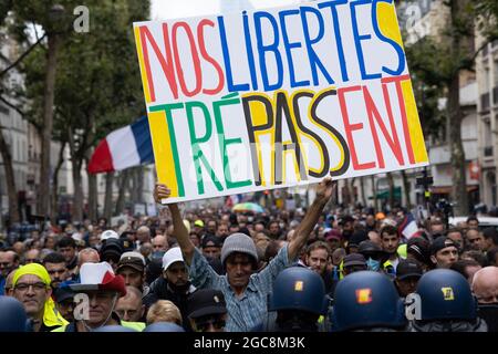 Il manifestante ( Voltuan ) ha dato un segno alla nostra caduta di libertà circondata dalle forze di gendarmeria e dalle forze di polizia durante una giornata nazionale di protesta contro la vaccinazione obbligatoria del Covid-19 per alcuni lavoratori e l'uso obbligatorio del certificato sanitario richiesto dal governo francese a Parigi il 7 agosto; 2021. Sabato i manifestanti sono scesi per le strade di tutta la Francia per il quarto fine settimana di fila per radunarsi contro un nuovo pass sanitario necessario per entrare in un bar o viaggiare su un treno interurbano, due giorni prima che le nuove regole entrino in vigore. Un pass sanitario valido è generato da due tamponi provenienti da un vaccino riconosciuto Foto Stock