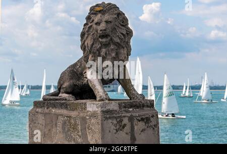 Statua di un leone sulla spianata di Cowes, Isola di Wight con yacht che si preparano a correre durante la settimana di Cowes 2021. Inghilterra, Regno Unito Foto Stock