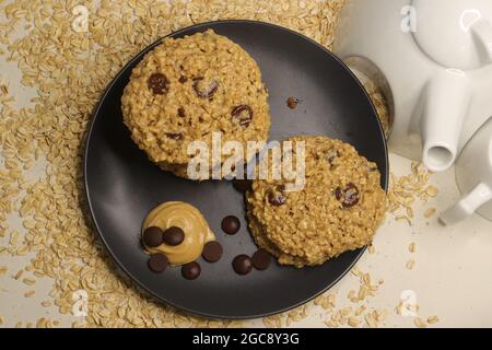 Burro di arachidi farinata d'avena Choco chips biscotti. Uno spuntino sano fatto in casa. Scatto su sfondo bianco. Foto Stock