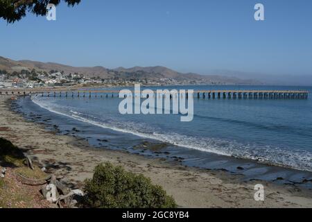 Cayucos state Beach con il molo di Cayucos sulla baia di estero. Nella contea di San Luis Obispo, California Foto Stock