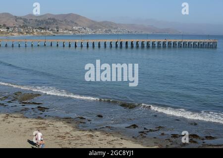 Cayucos state Beach con il molo di Cayucos sulla baia di estero. Nella contea di San Luis Obispo, California Foto Stock