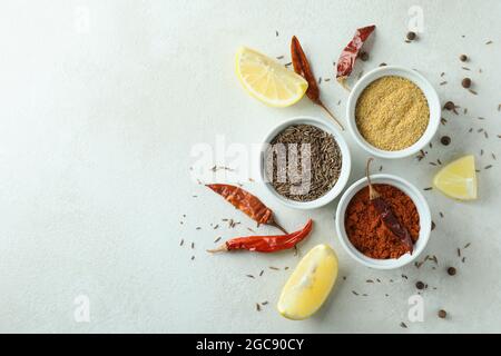 Spezie aromatiche in ciotole bianche su fondo testurizzato Foto Stock