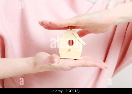 Donna che tiene piccola casa di legno. Idea di vita Foto Stock