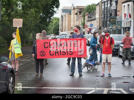 Cambridge, Regno Unito. 07 agosto 2021. I manifestanti hanno un banner che dice crisi climatica durante la dimostrazione.gli attivisti della ribellione estinzione hanno bloccato una strada principale a Cambridge in cinque minuti di intervalli per fermare il traffico ed evidenziare gli eventi meteorologici estremi di quest'anno e il modo in cui il clima sta cambiando. Credit: SOPA Images Limited/Alamy Live News Foto Stock