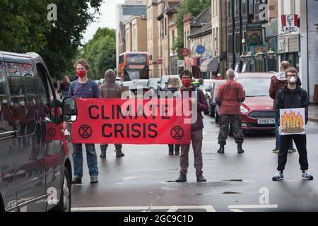 Cambridge, Regno Unito. 07 agosto 2021. I manifestanti hanno un banner che dice crisi climatica durante la dimostrazione.gli attivisti della ribellione estinzione hanno bloccato una strada principale a Cambridge in cinque minuti di intervalli per fermare il traffico ed evidenziare gli eventi meteorologici estremi di quest'anno e il modo in cui il clima sta cambiando. Credit: SOPA Images Limited/Alamy Live News Foto Stock