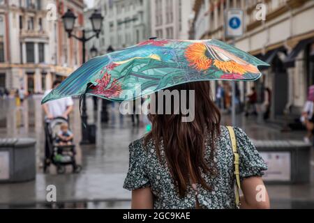 Mosca, Russia. 7 agosto 2021 UNA giovane ragazza con ombrello cammina lungo la via Kuznetsky Most nel centro di Mosca durante la pioggia, in Russia Foto Stock