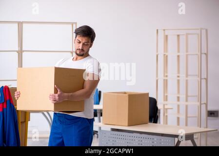 Giovane appaltatore in movimento concetto sul posto di lavoro Foto Stock