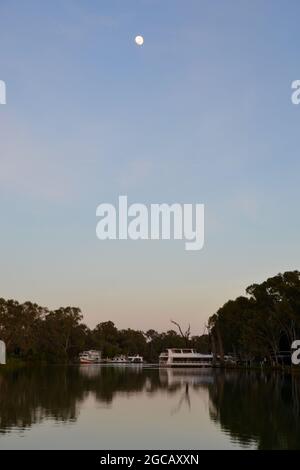 Moonrise sul tranquillo e tranquillo fiume Murray con grande cielo e case barche ormeggiate sullo sfondo Foto Stock