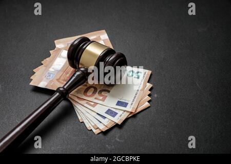 Giudice o asta gavel e banconote in euro su sfondo nero. Tangente, concetto di criminalità finanziaria. Spazio di copia, modello Foto Stock