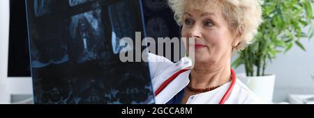 La donna anziana del medico sta tenendo il closeup di radiografia Foto Stock