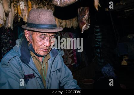 gli uomini tribali di apatani l'espressione facciale nella sua casa con immagine di sfondo sfocata è presa a ziro arunachal pradesh india. è una delle tribù più antiche Foto Stock