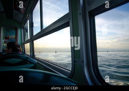 Vista della finestra del tramonto dalla barca a Venezia Foto Stock