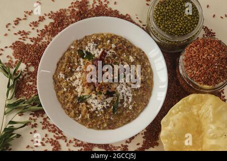 Porridge o gruel a base di riso Navara, fagioli mungs e semi di fieno cosparsi di cocco fresco grattugiato. Conosciuto anche come navara kichadi o uluva kanji Foto Stock