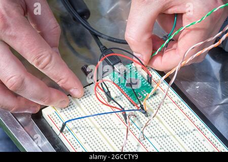 Collegare i contatti elettronici con le mani. Foto Stock