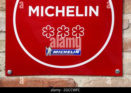 Vonnas, Francia - 23 febbraio 2017: Ristorante Michelin 3 stelle simbolo su un muro. Le guide Michelin sono una serie di guide Foto Stock