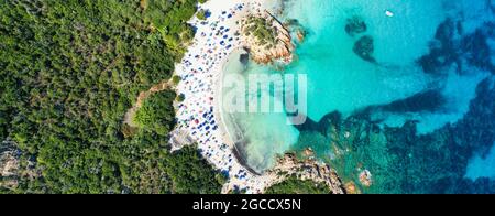 Vista dall'alto, splendida vista panoramica su una spiaggia di sabbia bianca piena di ombrelloni e persone che nuotano in un'acqua turchese. Foto Stock