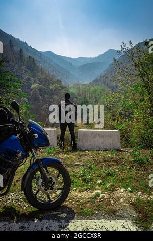 uomo motociclista con la sua moto e bella vista naturale al mattino immagine è presa a shergaon arunachal pradesh india. Foto Stock