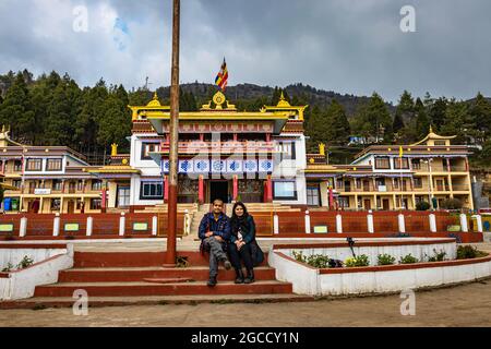 giovane coppia seduta di fronte all'antico monastero buddista colorato al giorno immagine è presa al monastero di bomdilla arunachal pradesh india. Foto Stock