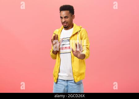 Phew lo take via da me. Sottacissimo disgustato intenso buon-look elegante maschio con barba in giacca urbana trendy giallo tirare le mani in NO o rifiuto Foto Stock