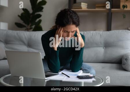 Primo piano donna stressata calcolando le fatture, avendo problemi con i soldi Foto Stock